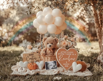 May include: A teddy bear sits in a wicker basket suspended by cream-colored balloons. The scene includes pumpkins, hearts, flowers, and a sign that reads "Baby Carter." A rainbow arches in the background, with the text "After every storm there is a Rainbow March 2026."