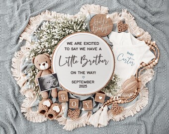 May include: A white letter board with the text "We are excited to say we have a little brother on the way! September 2025". The board is surrounded by a variety of baby-themed decorations, including a stuffed teddy bear, a baby onesie, and wooden blocks.