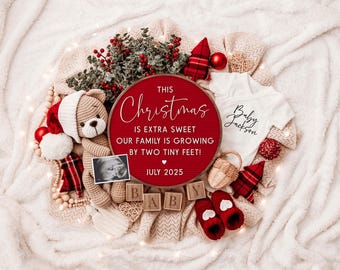 Könnte beinhalten: Ein rotes und weißes Weihnachts-Ankündigungszeichen mit dem Text "This Christmas is extra sweet our family is growing by two tiny feet! July 2025". Das Schild ist von Weihnachtsdekorationen umgeben, darunter ein Teddybär, ein Baby-Strampler und ein Korb.