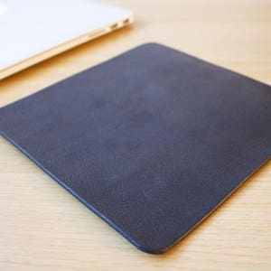 May include: A dark grey mouse mat made of a textured material.