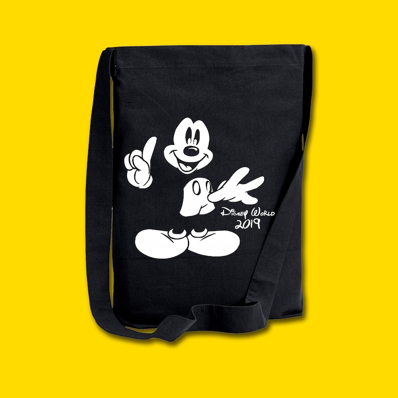 Puede incluir: Bolsa de lona negra con una silueta blanca de Mickey Mouse y el texto "Disney World 2019".