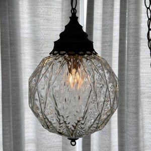 May include: A white ceramic mug with a black handle and the text "But First, Coffee" in a black, handwritten-style font. The mug is on a white surface.