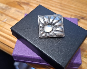 ARTS AND CRAFTS pewter and moonstone starburst brooch