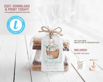 May include: A printable Easter favor tag featuring a bunny holding a basket of eggs. The tag is light blue with white text that says "Thank you for hopping by" and "Love, Nathan".