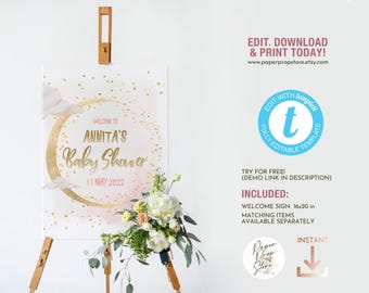 May include: A pink and gold welcome sign for a baby shower with a moon and clouds design. The sign says "Welcome to Annita's Baby Shower 11 May 2022".