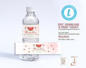 May include: Editable water bottle label template featuring a watercolor watermelon design with pink and red accents. The label says "Alexandra's First Birthday" with a date. The template is 2x8 inches.