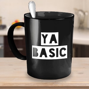 May include: Black ceramic coffee mug with white text that reads "YA BASIC".