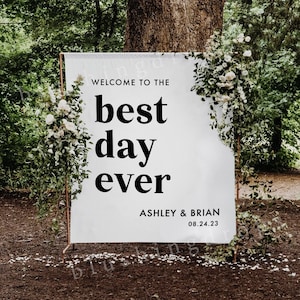 Pu&ograve; includere: Segno di matrimonio bianco con testo nero che dice "Benvenuti al giorno migliore di sempre" con i nomi Ashley & Brian e la data 08.24.23.