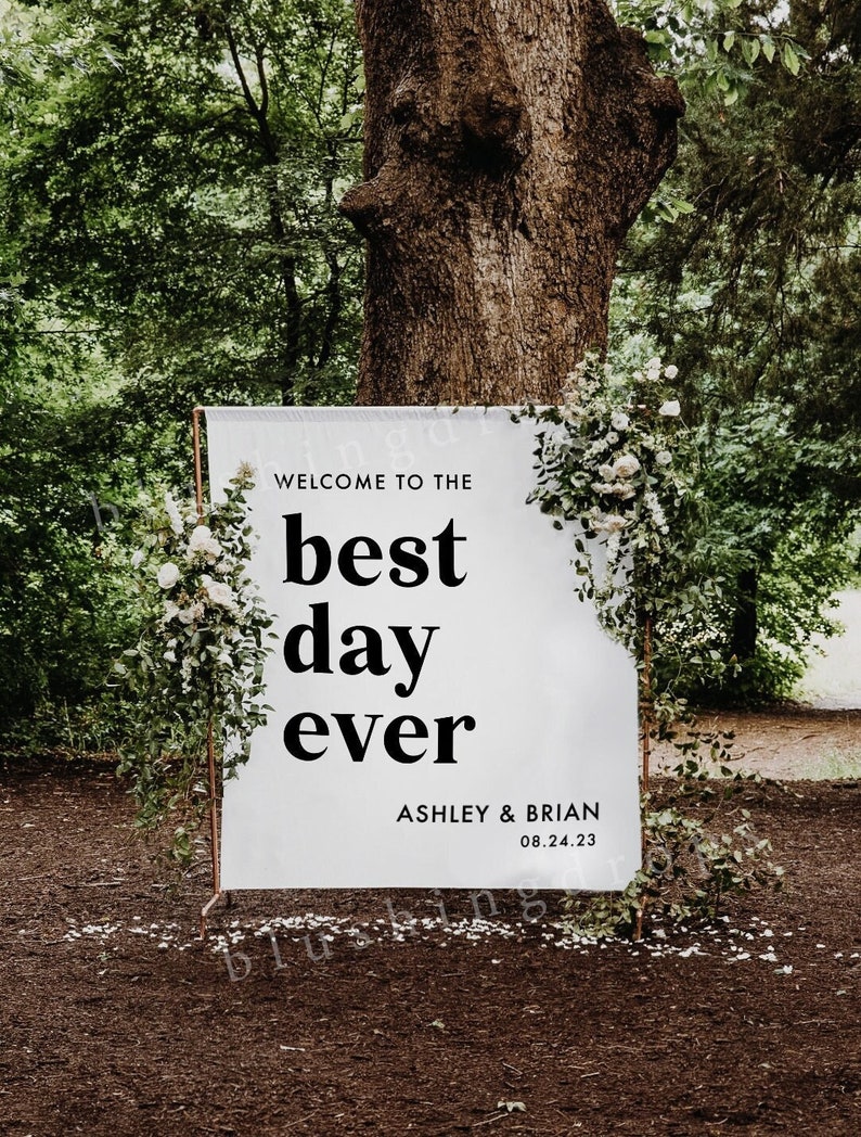 Pu&ograve; includere: Segno di matrimonio bianco con testo nero che dice "Benvenuti al giorno migliore di sempre" con i nomi Ashley & Brian e la data 08.24.23.