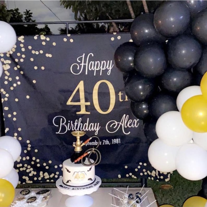 Puede incluir: Pancarta negra y dorada de Feliz 40 cumplea&ntilde;os con confeti dorado. Un pastel negro, blanco y dorado con una pipa de agua en la parte superior. Globos negros, blancos y dorados.