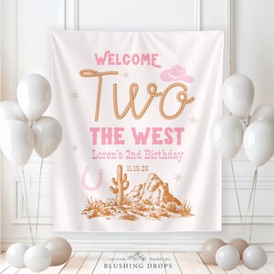 May include: A birthday party backdrop with the text "Welcome Two The West". The design features a cowboy hat, horseshoe, cactus, and desert landscape in pink and brown. White balloons are arranged around the backdrop, creating a festive atmosphere.