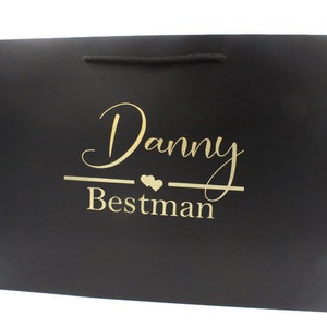 May include: Black gift bag with gold lettering that says "Danny Bestman" with two small hearts.