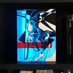 Może przedstawiać: Abstrakcyjny wydruk artystyczny w kolorach czarnym, białym, niebieskim i czerwonym. Wydruk przedstawia wirujący, organiczny wzór z czerwonym paskiem w środku.