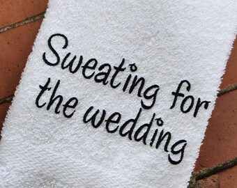 Könnte beinhalten: Weißes Handtuch mit schwarzem Sticktext, der "Sweating for the wedding" lautet.