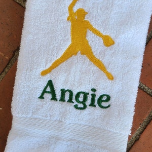 May include: White towel with a yellow embroidered softball player and the name Angie in green embroidery.