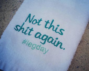 May include: White towel with teal embroidery that reads "Not this shit again. #legday"