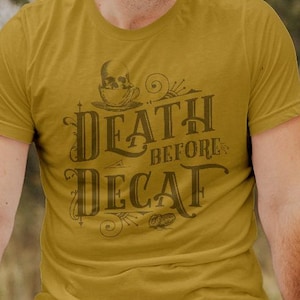 May include: A mustard yellow t-shirt with a vintage-style graphic that reads "Death Before Decaf" with a coffee cup illustration.