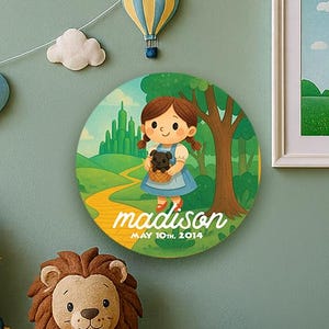 May include: A nursery scene with a Wizard of Oz theme. Features a framed Emerald City print, round wall art with a girl, and a princess doll. Decorative hot air balloons and clouds decorate the wall. The scene is set in a room.