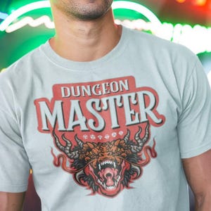 May include: A light gray t-shirt with a red, white, and black graphic of a dragon with the text "Dungeon Master" above it.