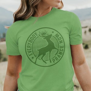 Op de afbeelding: Een groen T-shirt met een ronde afbeelding van een hert met de tekst "Everybody Mon France" eromheen.