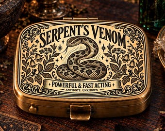 May include: A rectangular brass-toned metal tin featuring a black engraved illustration of a coiled snake. The lid displays the text "SERPENT'S VENOM," "POWERFUL & FAST ACTING," and "ANTIDOTE: UNKNOWN," surrounded by intricate floral and vine patterns.