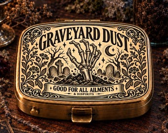 May include: A rectangular brass-toned metal tin featuring an engraved illustration of a skeleton hand emerging from a grave. The lid displays the text GRAVEYARD DUST, GOOD FOR ALL AILMENTS & DISPIRITS, surrounded by intricate floral and tombstone motifs.