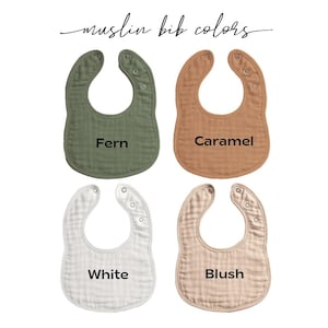 May include: Four muslin bibs in various colors: Fern, Caramel, White, and Blush. Each bib has a curved shape with snap closures at the neck. The text "muslin bib colors" is written in cursive at the top.