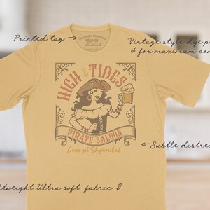 The High Tides Pirate Saloon tee has a vintage distressed design.  These shirts are so soft and comfy that you will want to wear it year round.  The designs and tags are dye printed for  comfort.   The shirts are available in many sizes and colors.