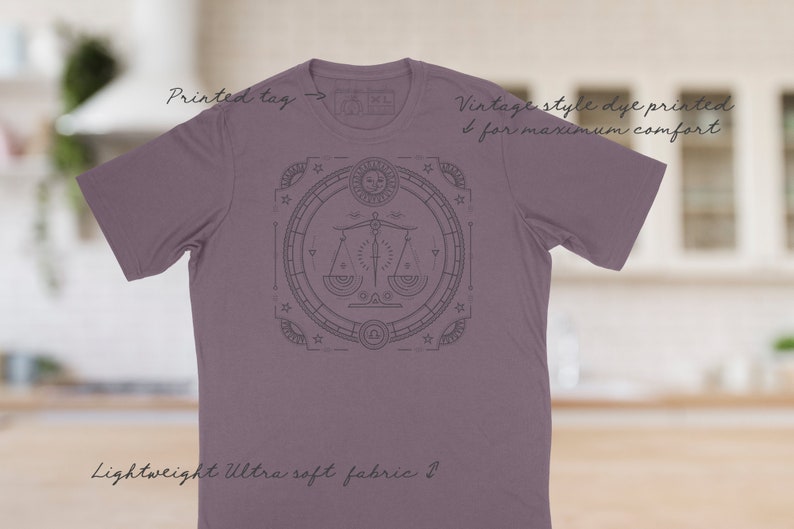 May include: A purple t-shirt with a vintage style dye print of a zodiac symbol. The symbol is a scale with a sword in the middle. The text "Vintage style dye printed for maximum comfort" is printed on the shirt. The text "Lightweight Ultra soft fabric" is printed on the bottom of the shirt.