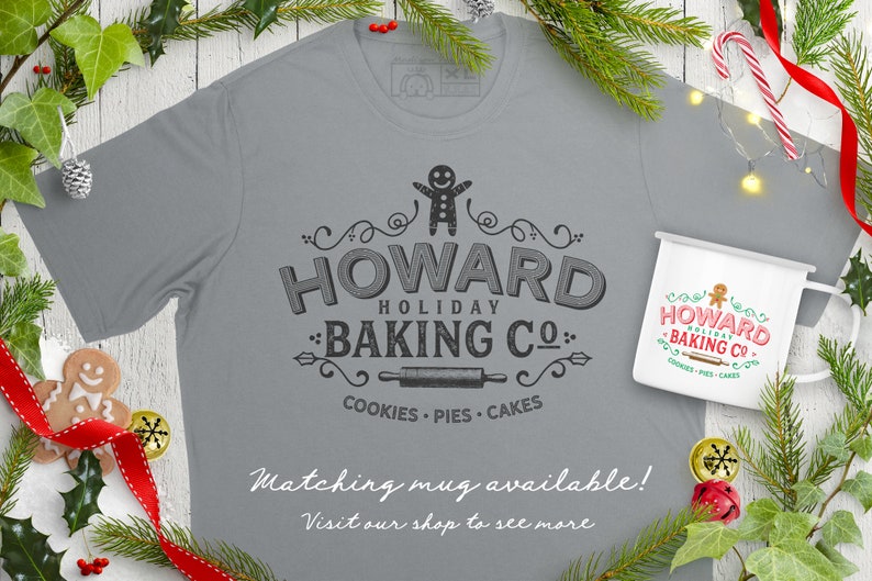 May include: A gray t-shirt with a vintage-style logo that says "Howard Holiday Baking Co." with a gingerbread man, rolling pin, and the words "Cookies, Pies, Cakes". A matching white mug with the same logo is also shown. The text "Matching mug available! Visit our shop to see more" is at the bottom of the image.