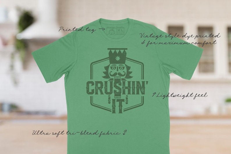 May include: Green t-shirt with a vintage style dye printed design featuring a nutcracker illustration and the text "Crushin' It".