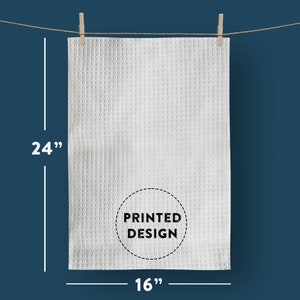 以下が含まれることがあります： 白のワッフル織りのキッチンタオルで、中央に「PRINTED DESIGN」と書かれた黒い円があります。タオルの幅は16インチ、長さは24インチです。