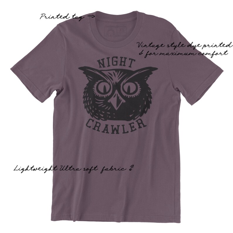 May include: Purple short-sleeved t-shirt with a black and white illustration of an owl with the text "NIGHT CRAWLER" printed on the front.