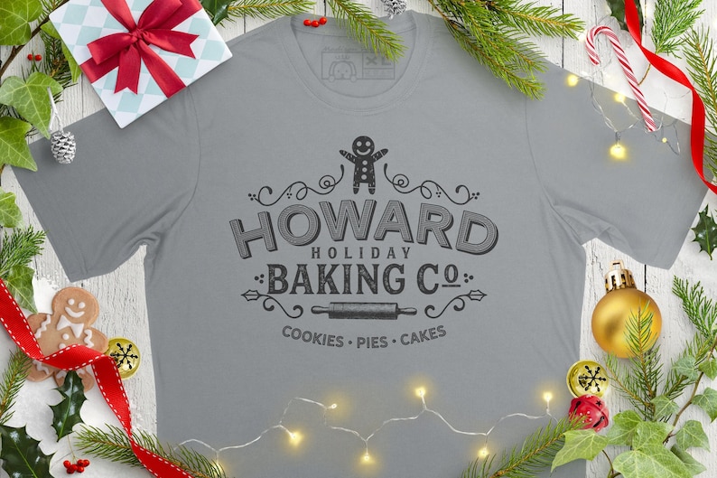 May include: A gray t-shirt with a vintage-style logo that says "Howard Holiday Baking Co." with a gingerbread man, rolling pin, and the words "Cookies - Pies - Cakes".