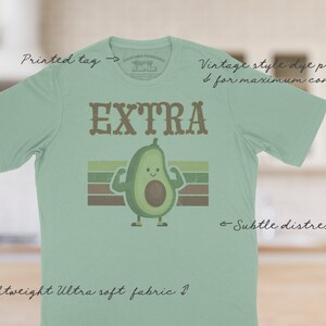 The Extra tee has a vintage distressed design.  These shirts are so buttery soft and comfy that you will want to wear it year round.  The designs and tags are dye printed for  comfort.   The shirts are available in many sizes and colors.