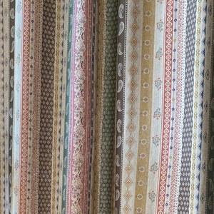 Puede incluir: Cortinas de rayas multicolores con un patrón de paisley. Las cortinas están hechas de una tela suave y tejida y presentan una variedad de colores, incluyendo rojo, verde, marrón y beige.