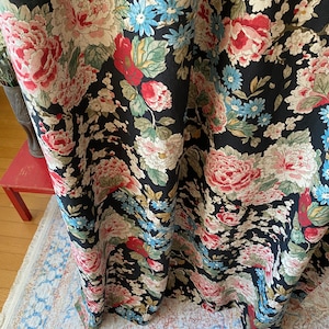 May include: Black floral fabric with large pink, red, and cream-colored peony blooms, accented by blue and green foliage. The fabric has a dark background and a detailed, vintage-inspired design, suitable for curtains or upholstery.