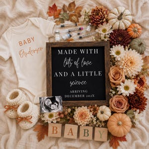 May include: A cream-colored baby bodysuit with the text Baby Andersen, a black sign with the text MADE WITH lots of love AND A LITTLE science ARRIVING DECEMBER 202X, a sonogram, medical syringes, knit booties, and autumn flowers and pumpkins.