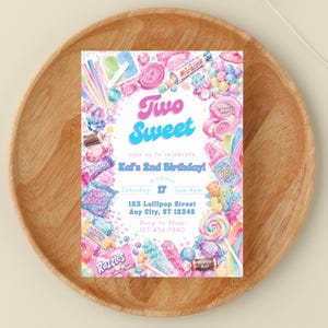 May include: A colorful invitation with a candy theme, featuring the text "Two Sweet" in blue and pink. The invitation includes details for a birthday party, with various candies and sweets illustrated around the edges. The invitation is on a wooden plate.
