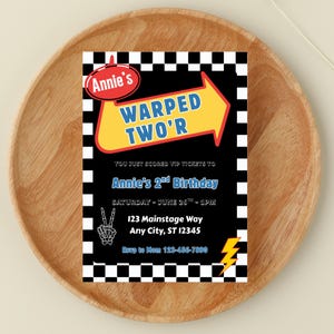 May include: A birthday party invitation with a black background and a checkered border. The invitation features the text "Annie's Warped Two'r" in a yellow arrow, along with event details and a lightning bolt graphic.