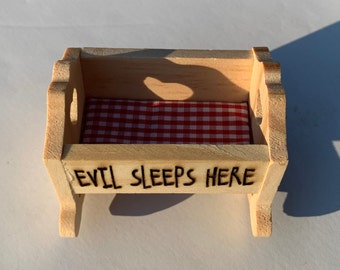 Evil Sleeps Here - creepy baby crib - tiny wooden rocker