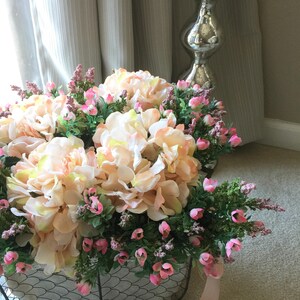 Basket of flowers. Lace detail. Flower, peach hydrangeas pink rose blooms. Faux flower arrangement. Large flower arrangement