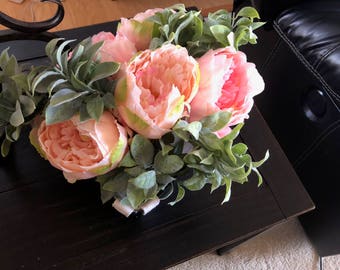 Pink and coral peony floral arrangement with soft greenery in a wire basket