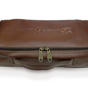 May include: A brown leather carrying case with a zipper closure and a handle. The case has the text "The Game of Kings" embossed on the top.