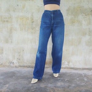 May include: A pair of blue denim jeans with a wide leg fit. The jeans have a high waist and a straight leg.