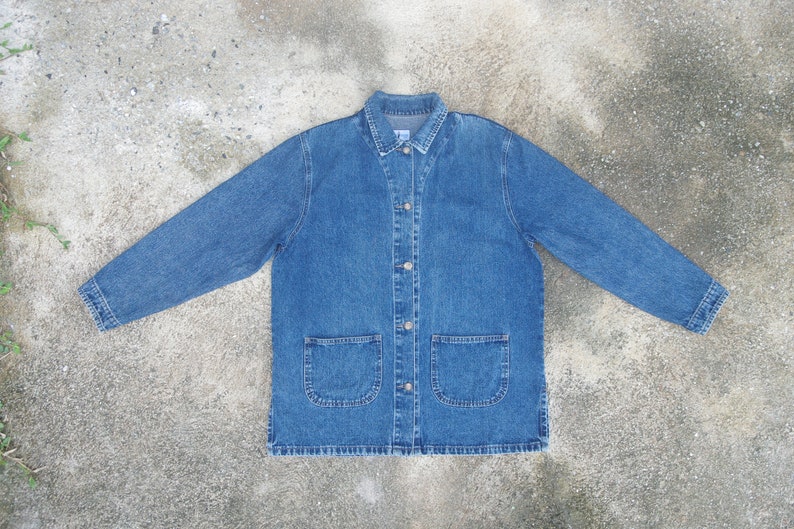 May include: A blue denim jacket with a button-up front, two large pockets on the front, and long sleeves.