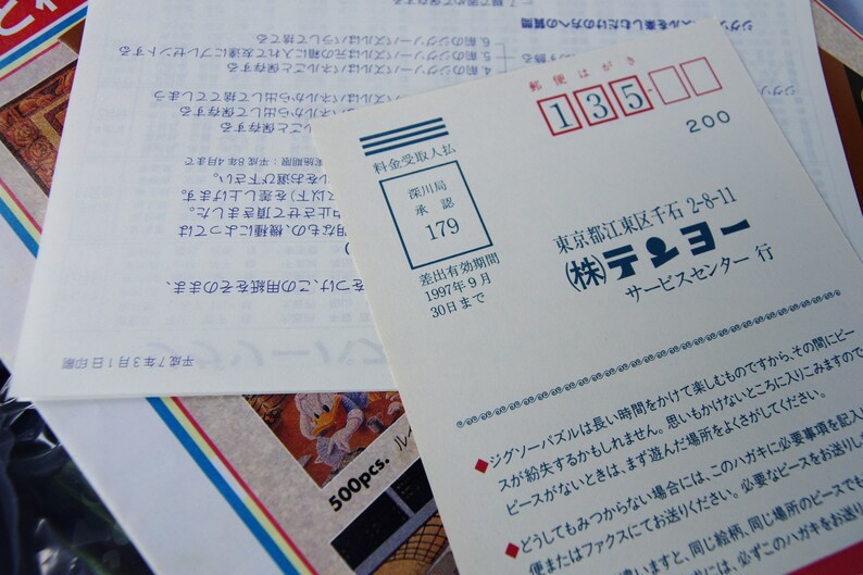 May include: A white card with blue text and a red stamp. The text reads "(株)テンヨー サービスセンター行" and "東京都江東区千石 2-8-11". The red stamp reads "深川局 承認 179".