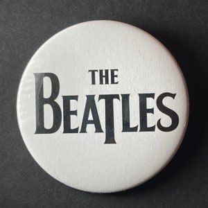 The Beatles black and white logo new, 2 1/4 inch in diameter pin/ button or magnet