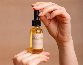 May include: A glass bottle of body oil with a dropper top. The label is brown with white text that reads "LONG HAATH CO. BODY OIL CITRUS & EUCALYPTUS" and includes a list of ingredients.