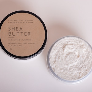 K&ouml;nnte beinhalten: Ein kleines Glas ungedufteter, geschlagene Sheabutter mit einem braunen Etikett, auf dem "CONCREATEDECOR.STORE HANDMADE IN NEW YORK SHEA BUTTER UNSCENTED I WHIPPED INGREDIENTS: SHEA BUTTER, COCONUT OIL 4OZ" steht.